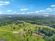 Scenic aerial view of a home nestled among green fields, woods, and distant lake with a clear sky backdrop at 357 Old Driver Rd, Whitesburg, GA 30185