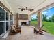 Relaxing covered patio with a brick fireplace, comfortable seating, and outdoor living space at 357 Old Driver Rd, Whitesburg, GA 30185