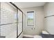 Bathroom featuring a white tiled shower with a glass door and a window for natural light at 357 Old Driver Rd, Whitesburg, GA 30185