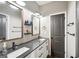 Bathroom featuring double sinks with dark countertops, white cabinets, and modern fixtures at 357 Old Driver Rd, Whitesburg, GA 30185