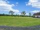 Sprawling green field with scattered trees next to an estate under a blue sky filled with fluffy clouds at 357 Old Driver Rd, Whitesburg, GA 30185