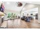 Open-concept living room with wood floors, modern ceiling fan, and view into the kitchen at 357 Old Driver Rd, Whitesburg, GA 30185