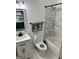 Bright bathroom featuring a toilet, shower over tub and a vanity with black fixtures at 441 Lilywood Dr, Mcdonough, GA 30253