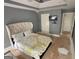Bedroom featuring a decorative tray ceiling, neutral walls, and bright natural light at 441 Lilywood Dr, Mcdonough, GA 30253