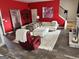 Bright living room with red accent wall, white sofas, and wood-look flooring at 441 Lilywood Dr, Mcdonough, GA 30253
