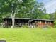 Charming single-story home with a large front yard, a covered porch and a beautiful garden at 5780 Hill Rd, Powder Springs, GA 30127
