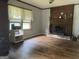 Living room featuring a brick fireplace and wood-look flooring at 5780 Hill Rd, Powder Springs, GA 30127