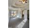Sunlit main bedroom boasting a tray ceiling, carpet, and ensuite bathroom entrance at 410 Oakpark Ter, Mcdonough, GA 30253