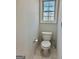 Clean and simple bathroom featuring a standard toilet and window for natural light at 410 Oakpark Ter, Mcdonough, GA 30253