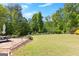 Backyard featuring a stone patio, lush landscaping, and mature trees, ideal for relaxation and entertaining at 266 Blue Point Pkwy, Fayetteville, GA 30215