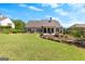 Expansive backyard with a manicured lawn, landscaped garden beds, and an outdoor fire pit at 266 Blue Point Pkwy, Fayetteville, GA 30215