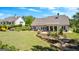 Well-manicured backyard featuring a patio, hot tub, lush lawn, and scenic landscaping, creating a peaceful outdoor oasis at 266 Blue Point Pkwy, Fayetteville, GA 30215