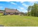 Expansive backyard featuring a stone patio, landscaped garden beds, and mature trees at 266 Blue Point Pkwy, Fayetteville, GA 30215