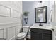 Stylish half bathroom with white wainscoting, blue walls, pedestal sink, and decorative mirror at 266 Blue Point Pkwy, Fayetteville, GA 30215