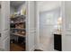 Walk-in pantry with wire shelving and a view into an adjacent tiled room with natural light at 266 Blue Point Pkwy, Fayetteville, GA 30215