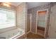 Bright bathroom featuring a soaking tub beneath a window, enclosed shower, and floral wallpaper at 250 Clearview Cir, Mcdonough, GA 30253