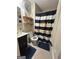 Bathroom with toilet, sink, mirror, shelves, and black and white shower curtain at 6070 Ridge Way, Douglasville, GA 30135
