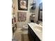 Bathroom with a single sink vanity, toilet, decorative shelves, and framed art at 6070 Ridge Way, Douglasville, GA 30135