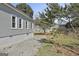 View of home's backyard and side featuring a gravel area and a tall, stone retaining wall at 1449 Wadley Ave, East Point, GA 30344