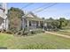 Home with manicured front yard, covered porch, black railings and black storm door at 1449 Wadley Ave, East Point, GA 30344