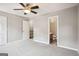 Bedroom featuring neutral walls, a ceiling fan, and easy access to the bathroom and hallway at 2049 Charter Ln, Lithonia, GA 30058
