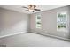 Bright bedroom featuring neutral walls, two large windows, and a ceiling fan for comfort at 2049 Charter Ln, Lithonia, GA 30058
