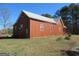 Angled view of home with red paneling, metal roof, and well-maintained lawn at 526 Mount Carmel Church Rd, Temple, GA 30179