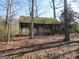 Image shows the exterior of an old gazebo with a mossy roof surrounded by trees at 526 Mount Carmel Church Rd, Temple, GA 30179