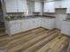 Kitchen featuring white cabinetry, laminate countertops and wood flooring at 526 Mount Carmel Church Rd, Temple, GA 30179