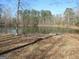 Scenic view of a tranquil pond surrounded by lush trees on a sunny day, showcasing the property's natural beauty at 526 Mount Carmel Church Rd, Temple, GA 30179