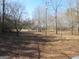 Expansive lot with scattered trees, power lines, and a charming home nestled in the background at 526 Mount Carmel Church Rd, Temple, GA 30179