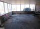 Image shows an empty sunroom with dirty concrete flooring at 526 Mount Carmel Church Rd, Temple, GA 30179