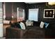 This living room features a dark brown sectional couch, stylish accent pillows, and modern graphic wallpaper at 116 Kalsum Trl, Ellenwood, GA 30294