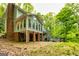 Spacious home exterior with brick and siding, featuring a large deck and outdoor entertainment space surrounded by lush trees at 120 Majesty Ln, Fayetteville, GA 30215