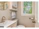 Powder room with white fixtures, decorative mirror, and charming stained glass window at 120 Majesty Ln, Fayetteville, GA 30215