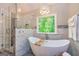 Bright bathroom features a soaking tub with window view and separate glass enclosed shower with marble tile at 120 Majesty Ln, Fayetteville, GA 30215