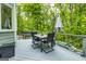 View of deck furnished with table and umbrella surrounded by lush trees at 120 Majesty Ln, Fayetteville, GA 30215
