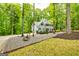 Stunning exterior of a two-story home surrounded by lush trees, with a long driveway and landscaping at 120 Majesty Ln, Fayetteville, GA 30215
