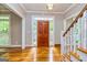 Inviting foyer with hardwood floors, wooden front door, and staircase with white railings at 120 Majesty Ln, Fayetteville, GA 30215