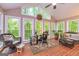 View of light-filled sunroom features brick flooring and a comfortable seating area at 120 Majesty Ln, Fayetteville, GA 30215