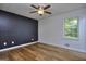 Bedroom with a modern accent wall, ceiling fan, and bright window at 130 Belmont Farms Dr, Ellenwood, GA 30294