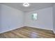 Well-lit, empty bedroom with hardwood floors and a bright window view at 130 Belmont Farms Dr, Ellenwood, GA 30294