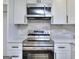 Up close view of stainless steel oven and microwave in a newly updated kitchen at 130 Belmont Farms Dr, Ellenwood, GA 30294