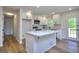 This modern white kitchen features a white island, stainless steel appliances, and lots of natural light at 130 Belmont Farms Dr, Ellenwood, GA 30294