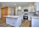 Bright white kitchen features quartz counters, stainless appliances, and an eat-in island at 130 Belmont Farms Dr, Ellenwood, GA 30294