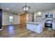 The open kitchen and living area features white cabinets, an island, a ceiling fan, and natural light at 130 Belmont Farms Dr, Ellenwood, GA 30294