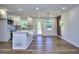 A bright white kitchen features quartz counters, stainless appliances, an island, and a view to the rear yard at 130 Belmont Farms Dr, Ellenwood, GA 30294