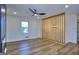 Bright, modern living room features wood floors, black ceiling fan, and unique wood slat wall partition with chandelier at 130 Belmont Farms Dr, Ellenwood, GA 30294
