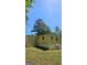 A yellow home with a visible basement section, set against a backdrop of lush trees and a bright sky at 1973 Niskey Lake Sw Rd, Atlanta, GA 30331