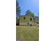 A yellow home with a visible basement section, set against a backdrop of lush trees and a bright sky at 1973 Niskey Lake Sw Rd, Atlanta, GA 30331
